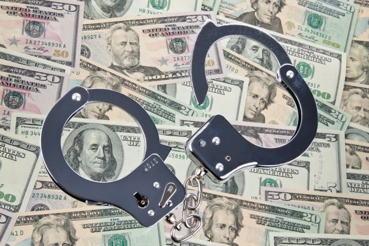 False pretenses- Photo of cash and handcuffs